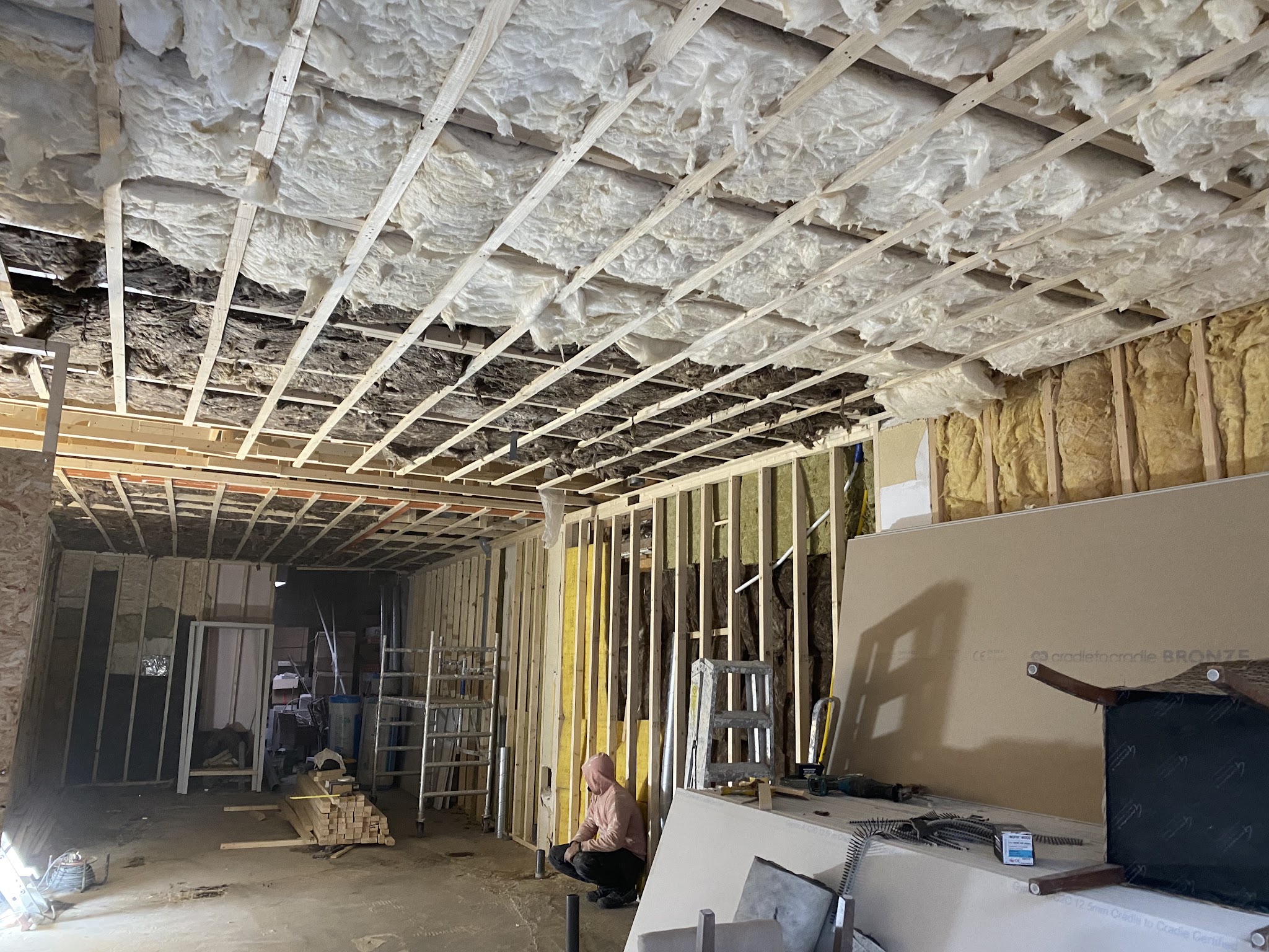 Verbouwing met open plafond, regelwerk, isolatie en stijlwerk langs de wanden